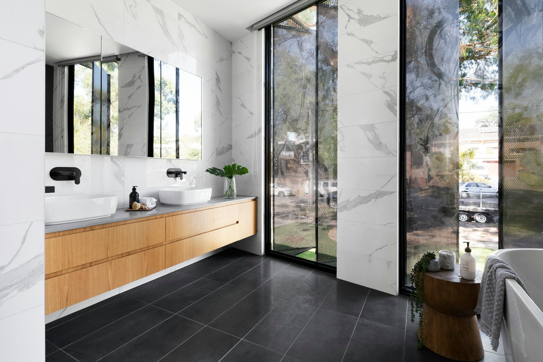 Bright, design-led bathroom with marble surfaces and warm timber cabinetry